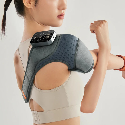 Person wearing a shoulder massager with digital display on a plain background